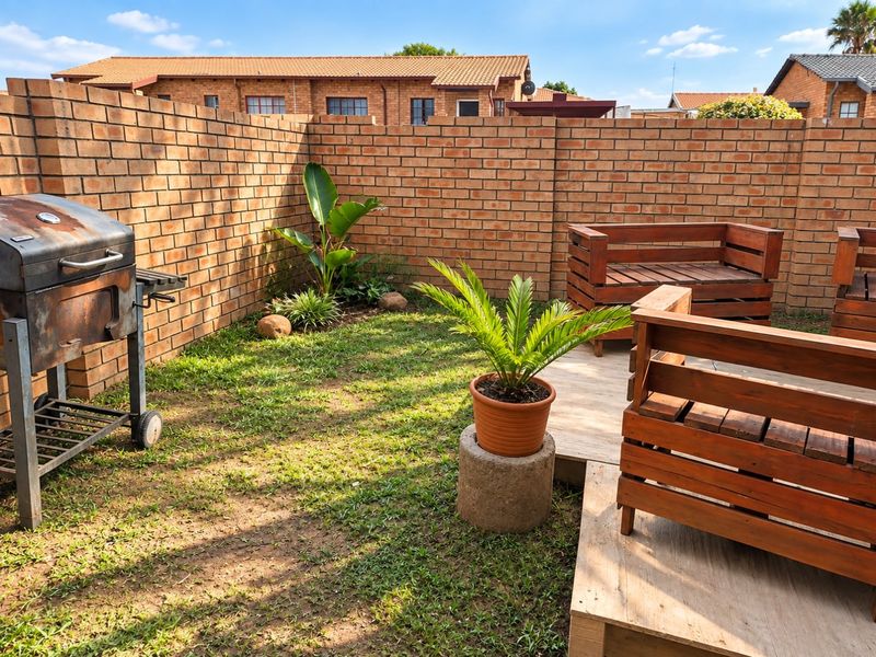 A private rear garden area featuring a brick boundary wall and a small lawn, providing a functional outdoor space for relaxation.