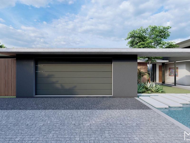 Modern residential front facade featuring a sleek garage door, concrete driveway, and a contemporary water feature with stepping stones.