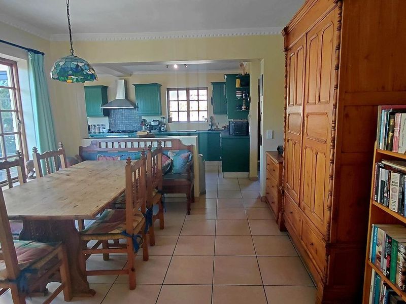 Open plan dining and kitchen area featuring tiled floors, green cabinetry, and a functional layout with integrated cooking appliances.