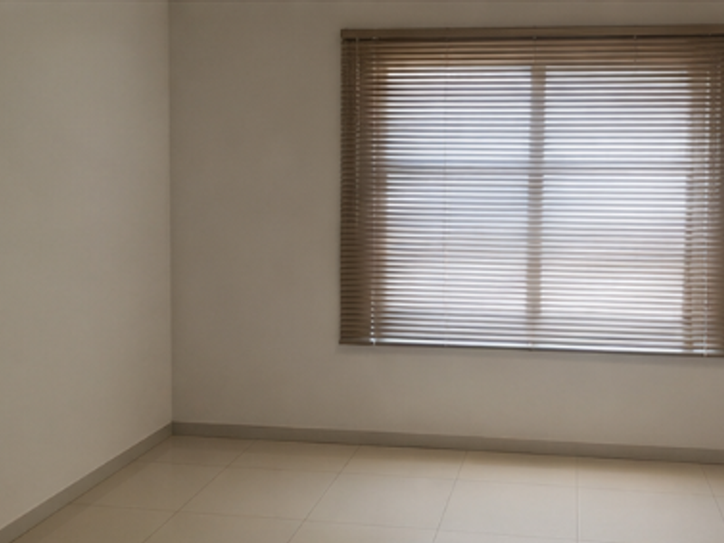 A clean, empty office space featuring neutral tiled flooring and fitted venetian blinds, providing a bright and versatile workspace.