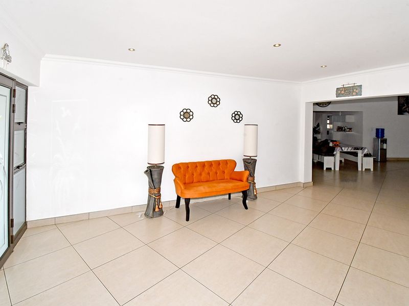 Spacious living area featuring neutral tiled flooring, recessed downlighting, and a sliding glass door leading to the exterior.