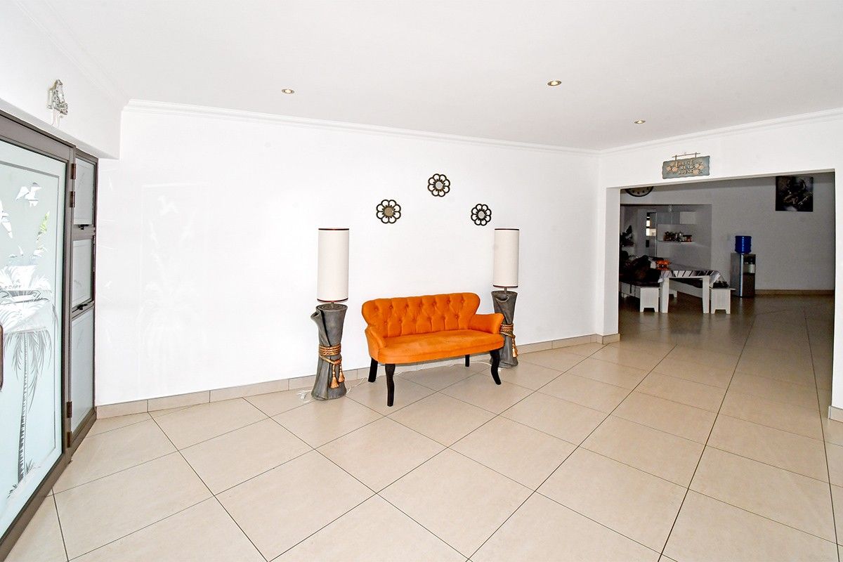 Spacious living area featuring neutral tiled flooring, recessed downlighting, and a sliding glass door leading to the exterior.