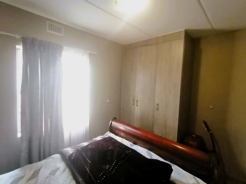 A bedroom featuring a built-in wardrobe and natural light from the window.