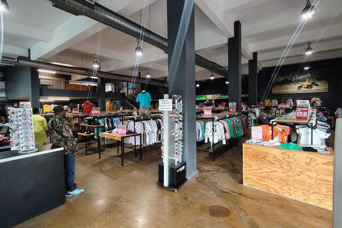 Spacious retail floor featuring industrial-style exposed ducting, polished concrete flooring, and a mezzanine level, providing an open-plan layout suitable for various commercial uses.