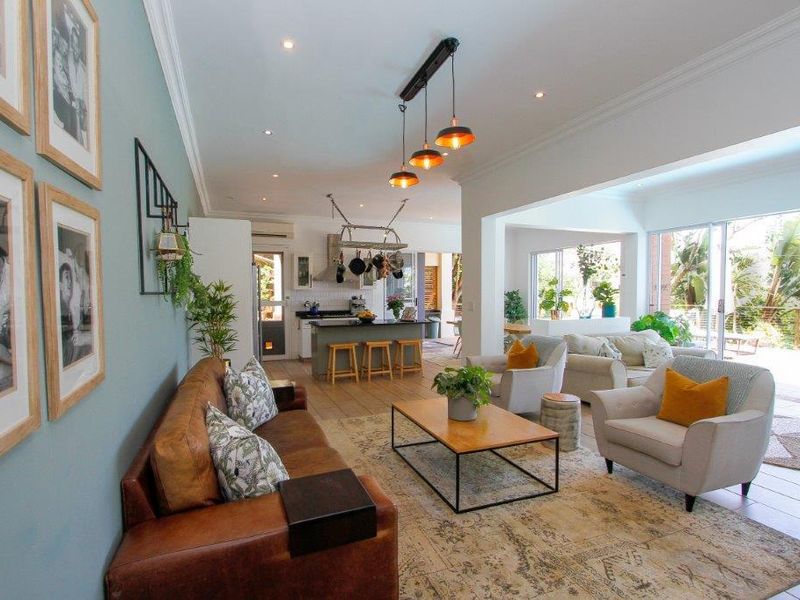 Spacious open-plan living area featuring a modern kitchen with island, recessed lighting, and large sliding doors leading to an outdoor space.