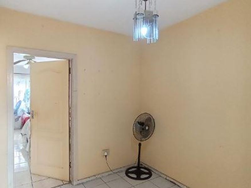 An empty bedroom featuring tiled flooring and a central ceiling light fixture, presenting a blank canvas for potential renovation or restyling.