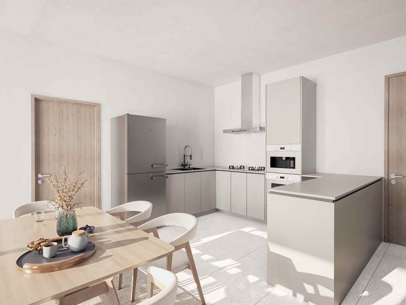 A modern open-plan kitchen and dining area featuring sleek cabinetry, integrated appliances, a stainless steel extractor fan, and a functional kitchen island.