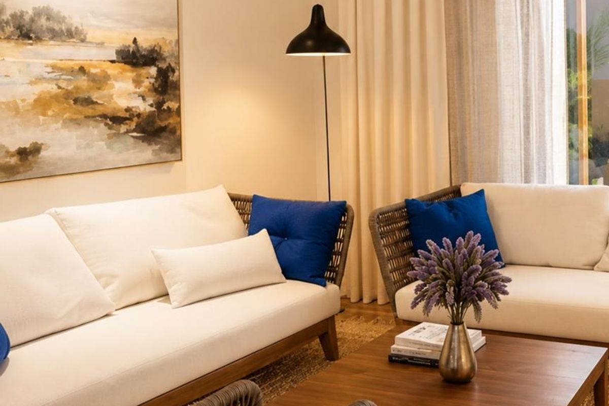 A well-appointed living room featuring neutral tones, floor-to-ceiling curtains, and direct access to an outdoor area.