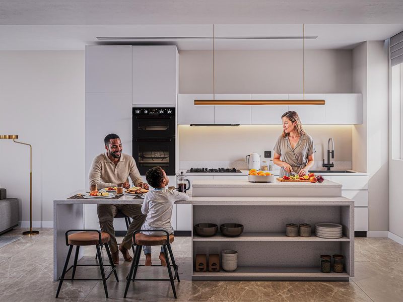 Modern open-plan kitchen featuring sleek white cabinetry, integrated appliances, stone countertops, and a central island with breakfast bar seating.