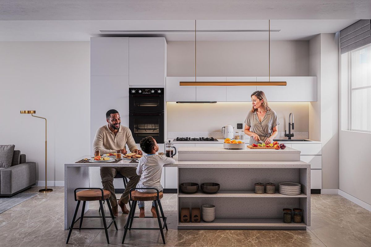 Modern open-plan kitchen featuring sleek white cabinetry, integrated appliances, stone countertops, and a central island with breakfast bar seating.