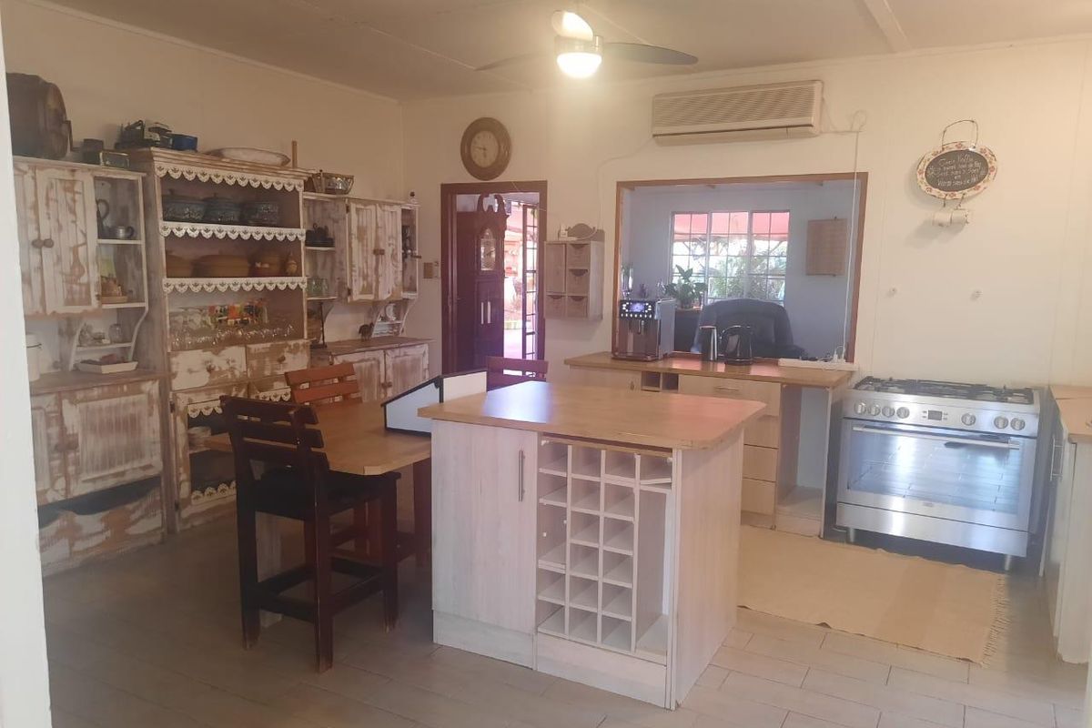 A functional kitchen featuring a central island with wine storage, a gas stove, and built-in cabinetry, offering a practical layout for daily cooking.