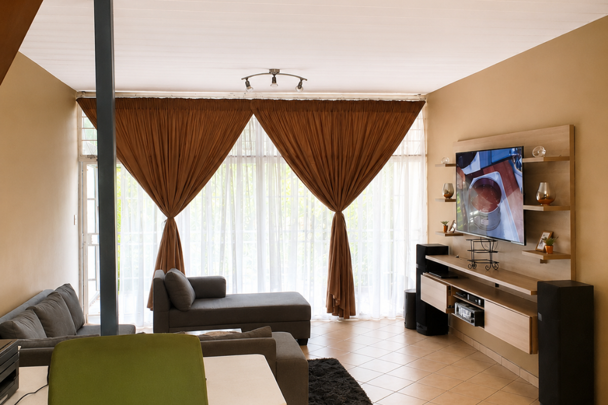 A living room featuring tiled flooring, a built-in media console, and large windows with curtains leading to an outdoor area.