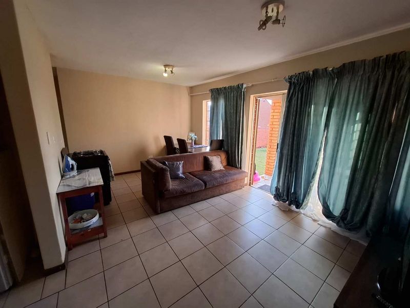 Open plan living area featuring tiled flooring and a sliding glass door providing direct access to the outdoor space.
