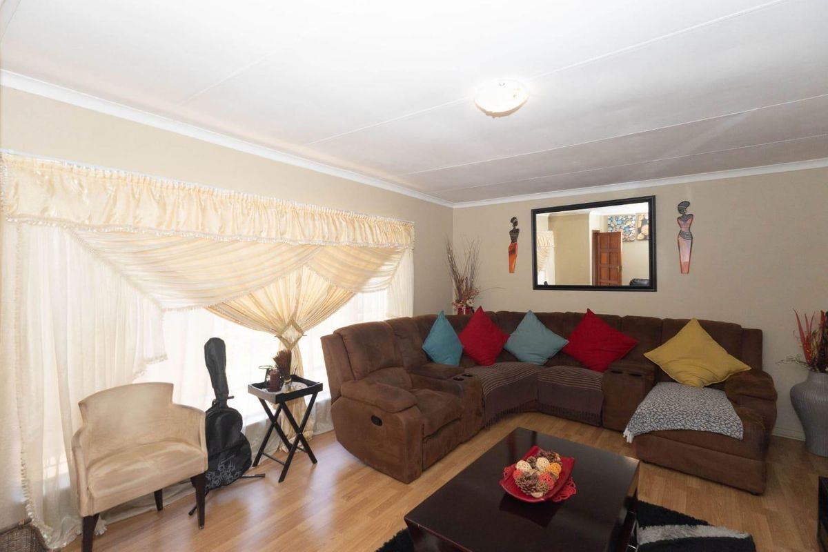 A comfortable living room featuring laminate flooring and a central ceiling light fixture.
