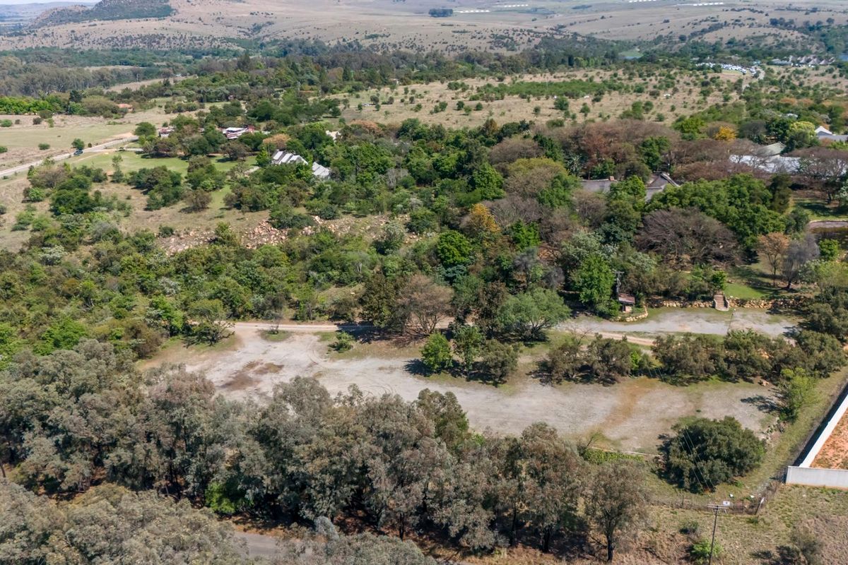 An aerial view of the expansive small holding property, showcasing the large plot, mature vegetation, and surrounding landscape.