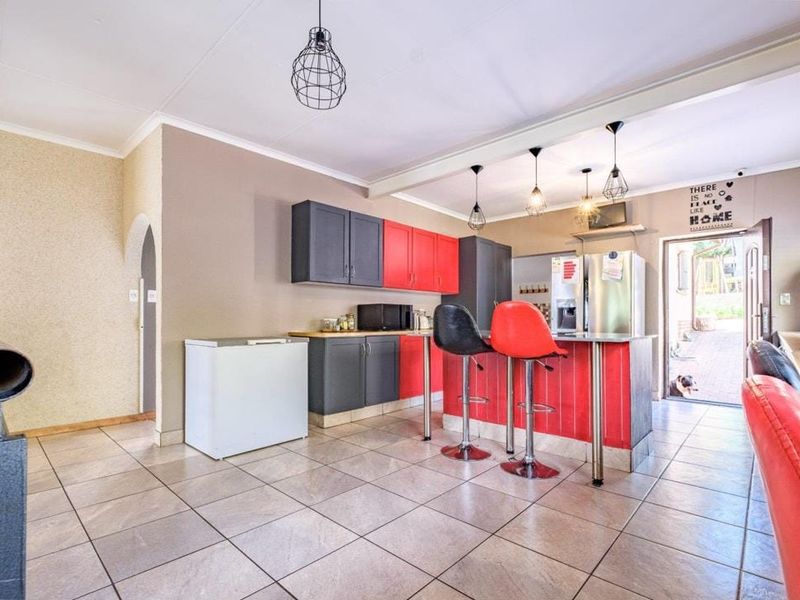Kitchen featuring a central island with breakfast bar seating, two-tone cabinetry, and tiled flooring, with direct access to an outdoor area.