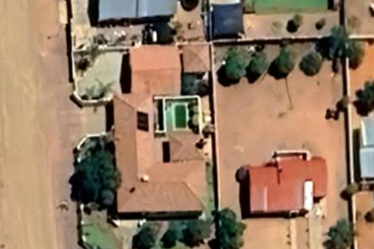 An aerial satellite view of the property showing the house layout, swimming pool, and surrounding grounds.