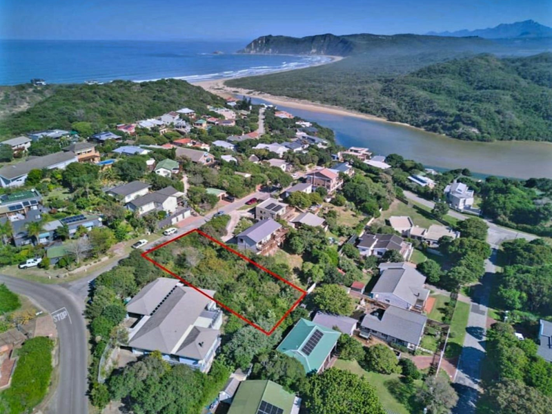 Aerial view of a vacant residential plot situated in a coastal neighborhood, highlighting the surrounding landscape and proximity to the beach.