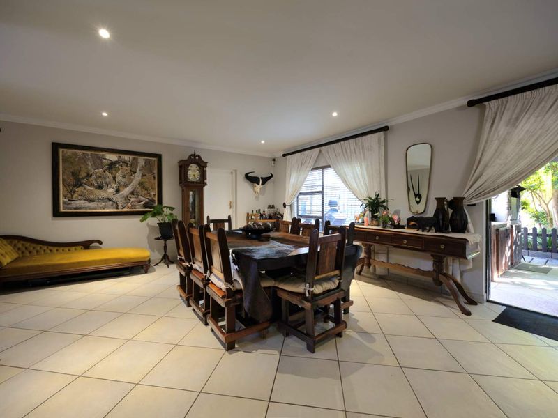 Spacious dining room featuring neutral tiled flooring, recessed lighting, and direct access to an outdoor patio area through a sliding glass door.
