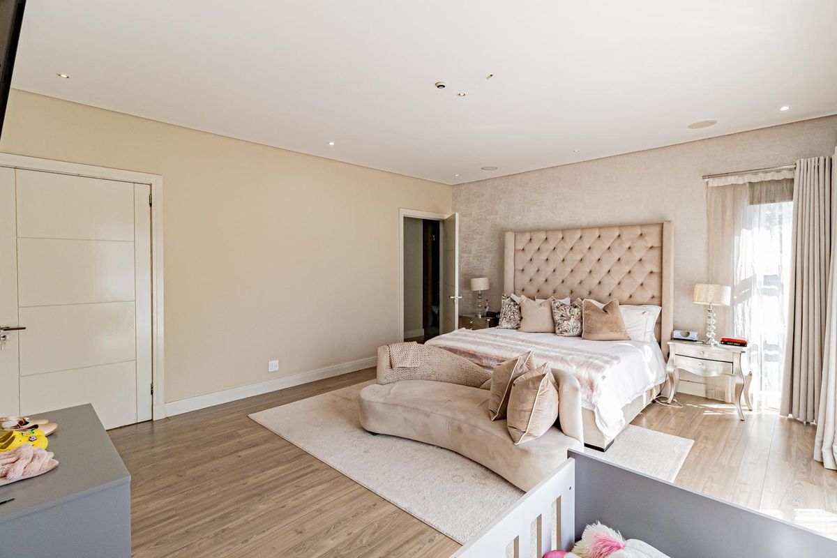 Spacious bedroom featuring neutral tones, recessed ceiling lighting, and wood-look flooring, creating a comfortable and well-maintained living space.