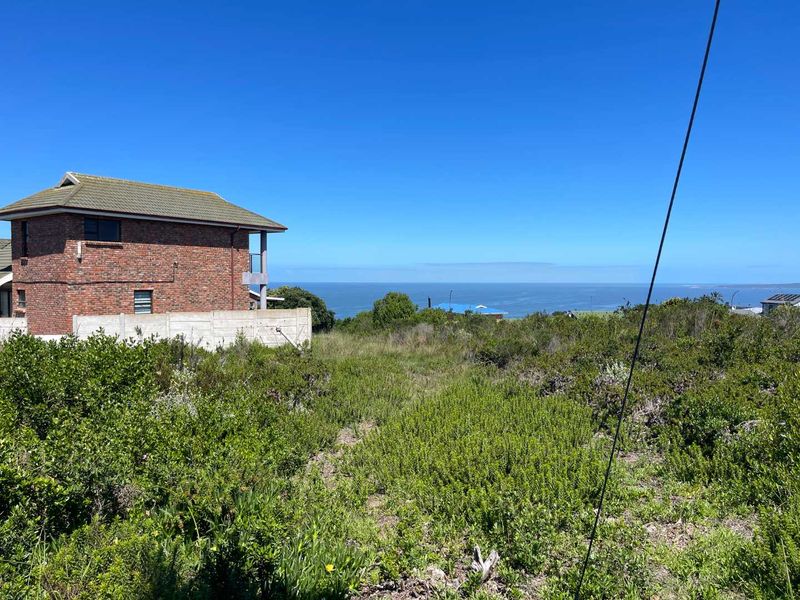 A view of the coastal landscape and ocean from the vacant residential property, featuring natural vegetation and surrounding residential development.