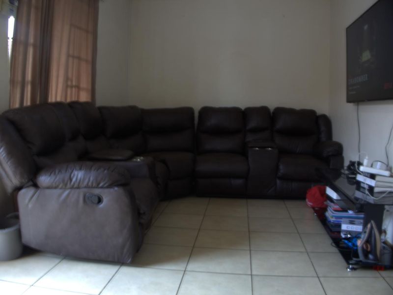 A living room area featuring tiled flooring and neutral wall finishes, providing a functional space for relaxation.