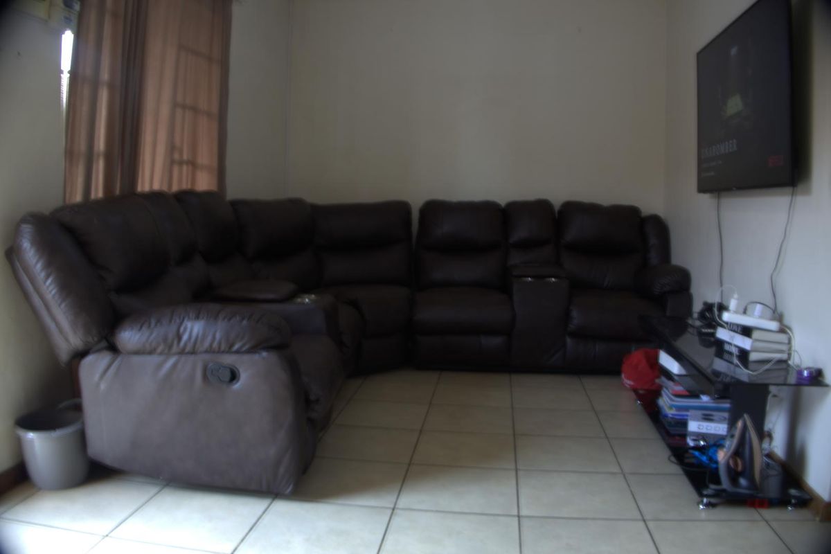 A living room area featuring tiled flooring and neutral wall finishes, providing a functional space for relaxation.