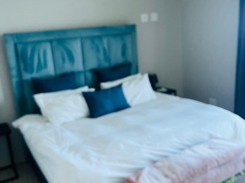 A bedroom featuring neutral wall tones, recessed ceiling lighting, and laminate flooring.