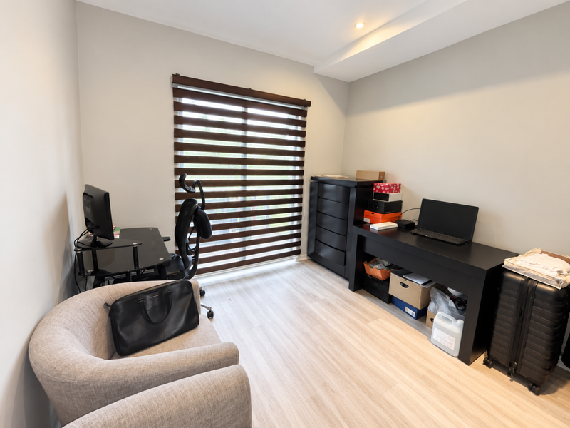 A functional home office space featuring light-toned laminate flooring, recessed ceiling lighting, and modern roller blinds, providing a clean and neutral work environment.