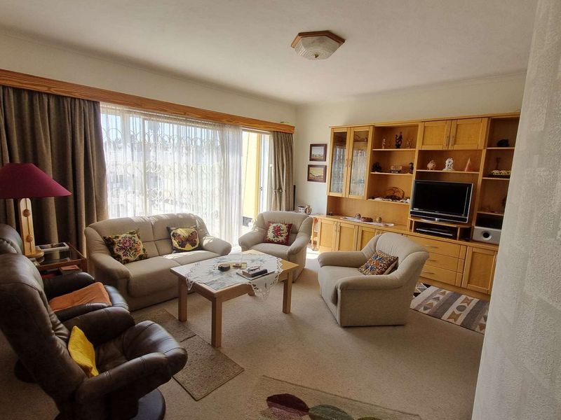 A spacious living room featuring built-in wooden cabinetry and large sliding glass doors that provide access to the outdoor area.