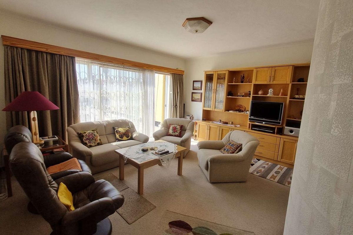 A spacious living room featuring built-in wooden cabinetry and large sliding glass doors that provide access to the outdoor area.