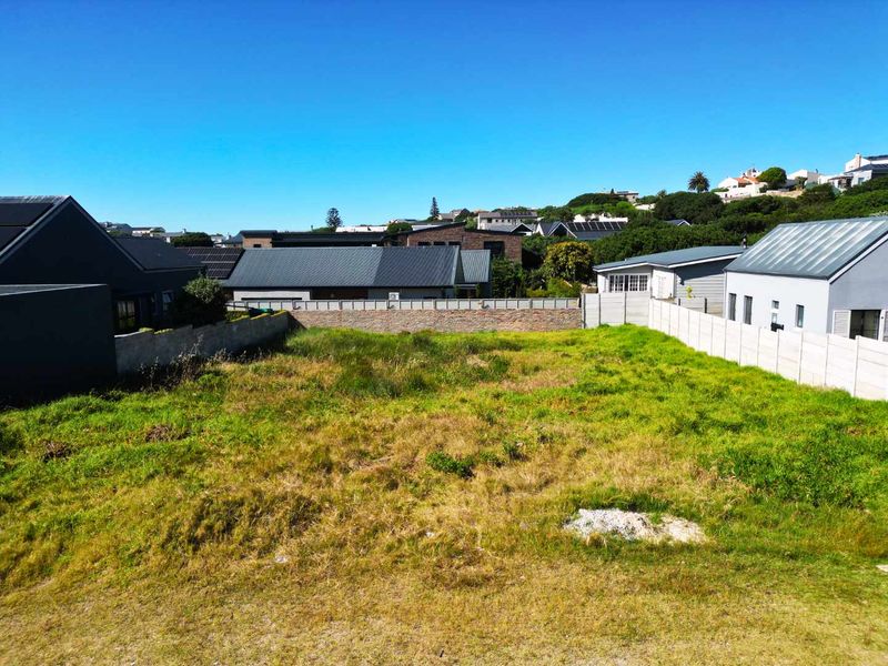A vacant residential plot featuring established boundary walls and surrounding neighborhood views, offering a clear space for potential development.