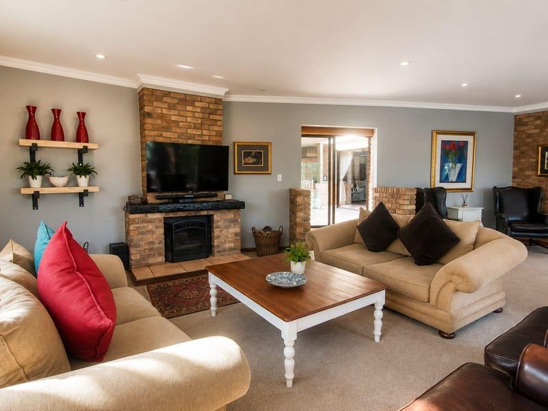 Spacious living room featuring a prominent brick fireplace, recessed lighting, and sliding glass doors leading to an outdoor area.