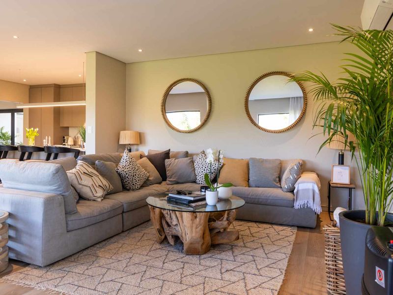 A bright and modern open-plan living area featuring recessed lighting, air conditioning, and high-quality hardwood flooring, seamlessly connected to the kitchen space.
