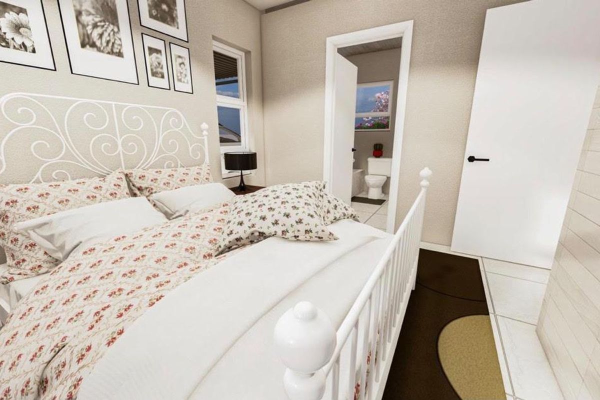 A well-lit bedroom featuring neutral wall tones, tiled flooring, and an adjoining en-suite bathroom with a visible toilet.