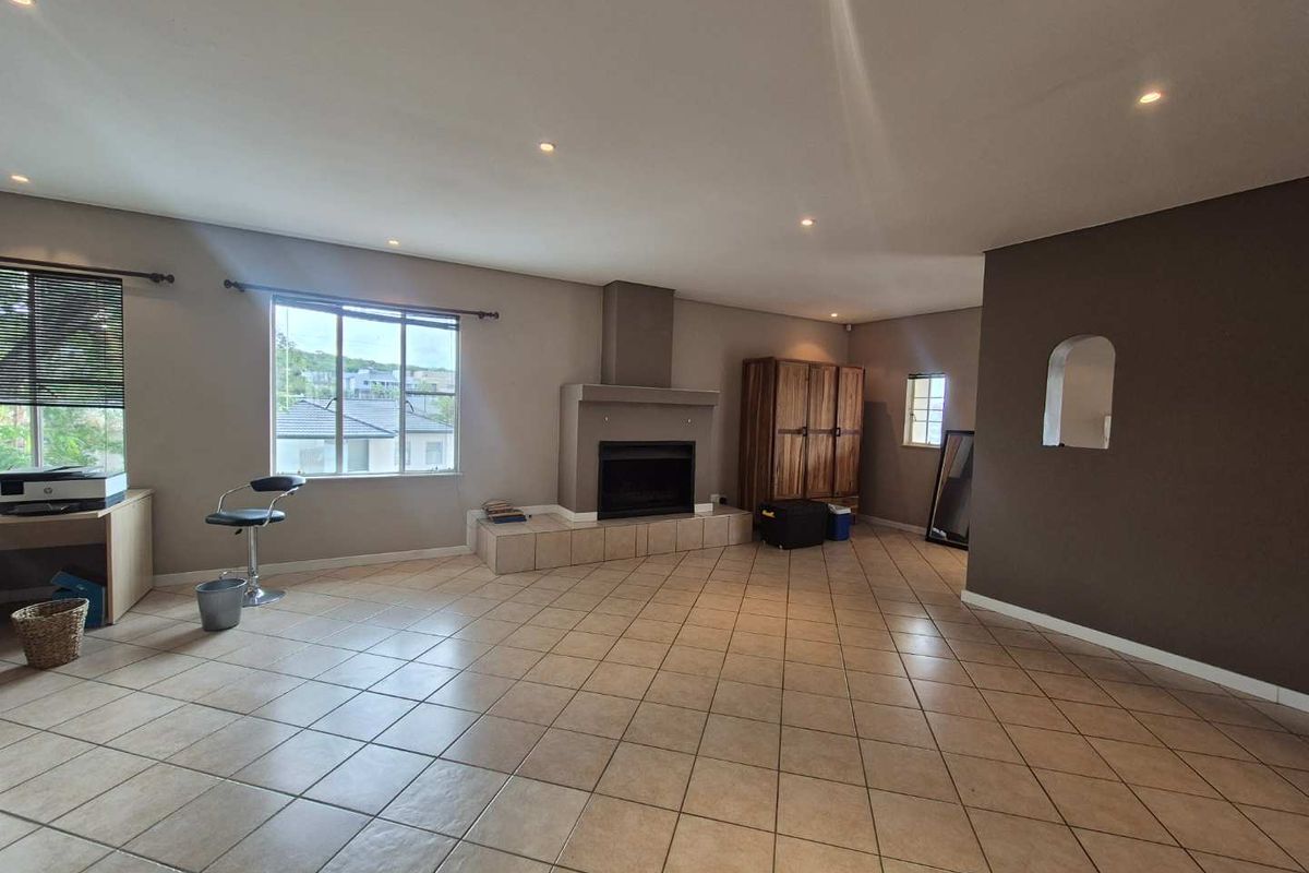 Spacious living room featuring tiled flooring, recessed ceiling lighting, and a built-in fireplace with a tiled hearth.