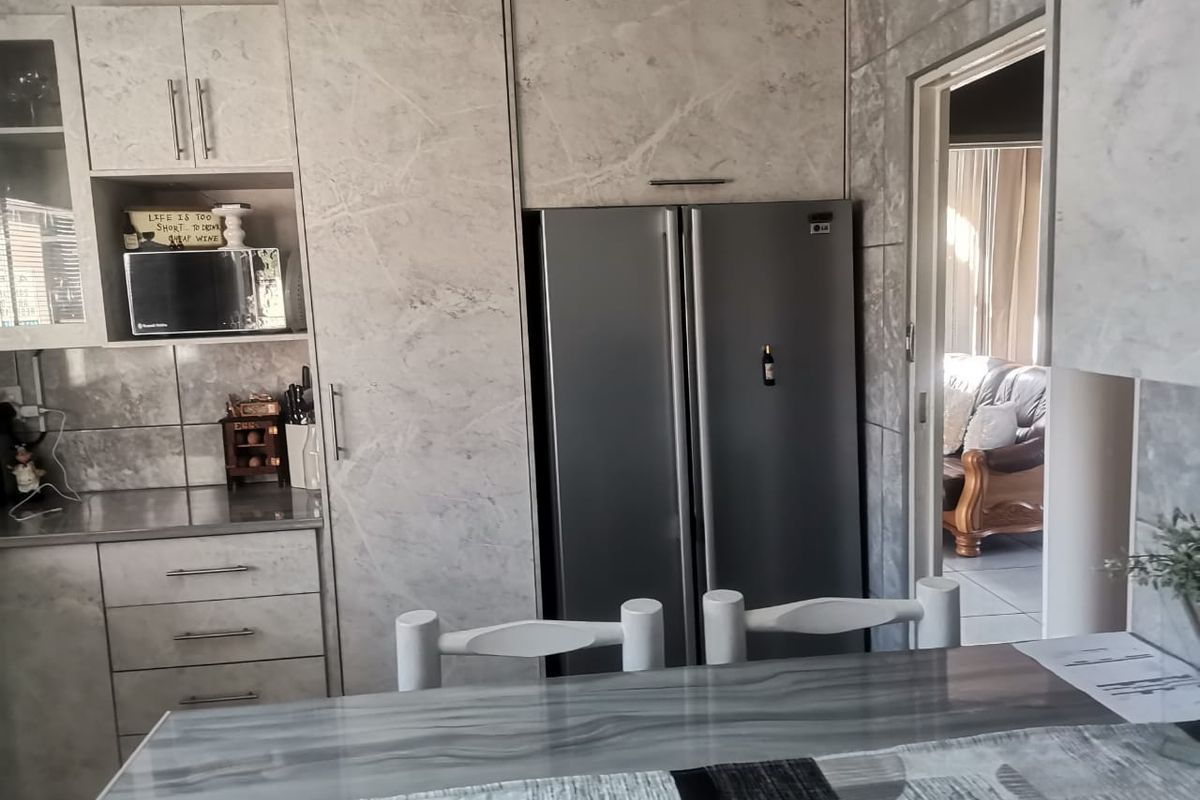 Modern kitchen featuring marble-effect cabinetry, integrated storage, and a sleek countertop, providing a functional and stylish culinary space.