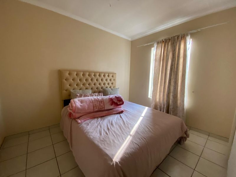 A standard bedroom featuring tiled flooring and coved ceiling details, providing a neutral foundation for personal styling.