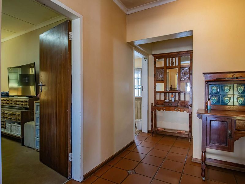 A functional hallway featuring tiled flooring and access to adjacent rooms through wooden doors.