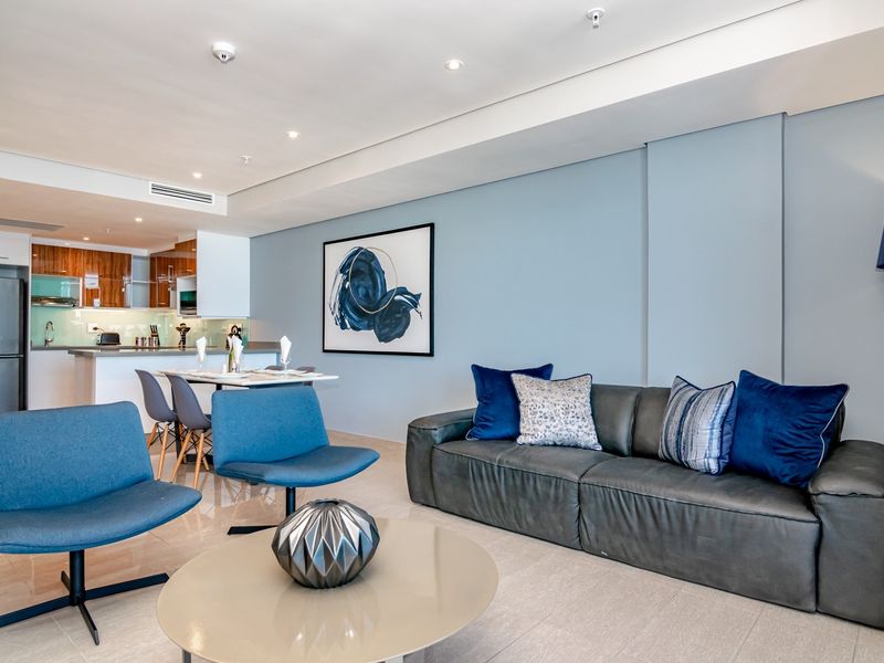 Modern open-plan living and dining area featuring tiled floors, recessed lighting, ducted air conditioning, and a sleek kitchen with contemporary cabinetry.