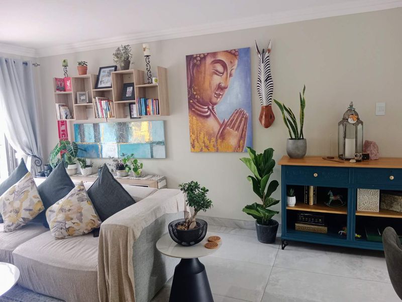 A well-maintained living room featuring neutral wall tones, tiled flooring, and coved ceiling details, creating a comfortable and inviting residential space.