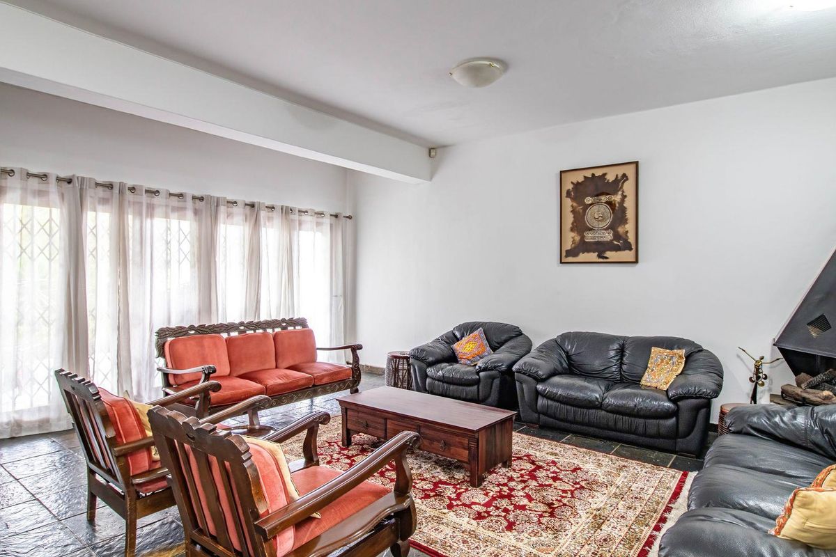 Spacious living room featuring slate tile flooring, a built-in fireplace, and large sliding glass doors providing access to the exterior.