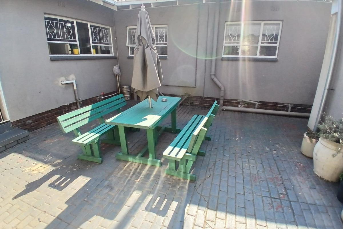 A rear courtyard area featuring brick paving and exterior wall access, providing a functional outdoor space with potential for landscaping improvements.