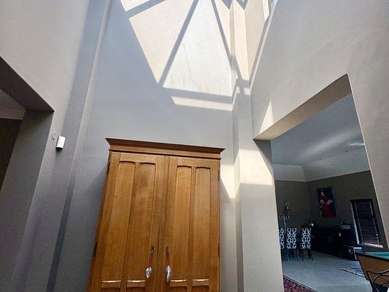 Spacious entrance hall featuring a dramatic vaulted ceiling with a large skylight, providing abundant natural light and an airy atmosphere.