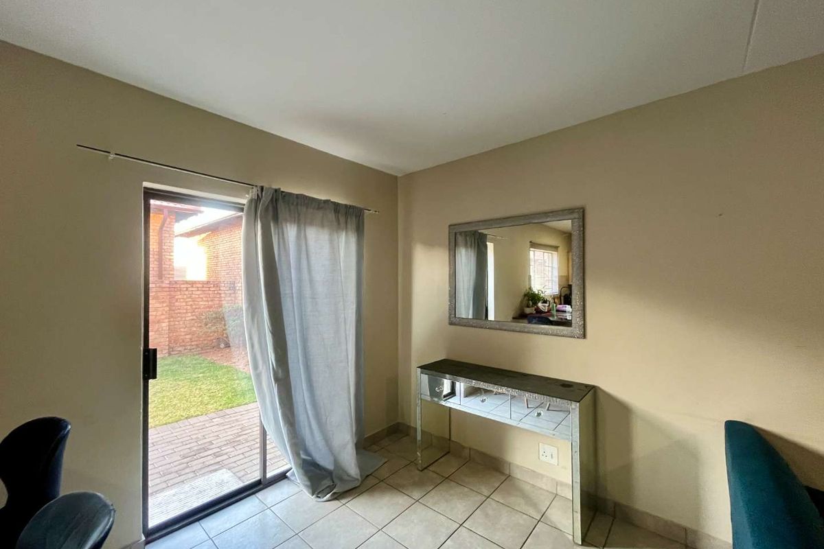 A living area featuring tiled flooring and a sliding glass door providing direct access to the rear garden.