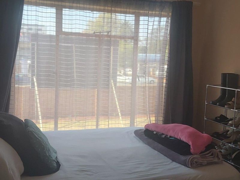 A bedroom featuring a large window with natural light, providing a view of the exterior surroundings.