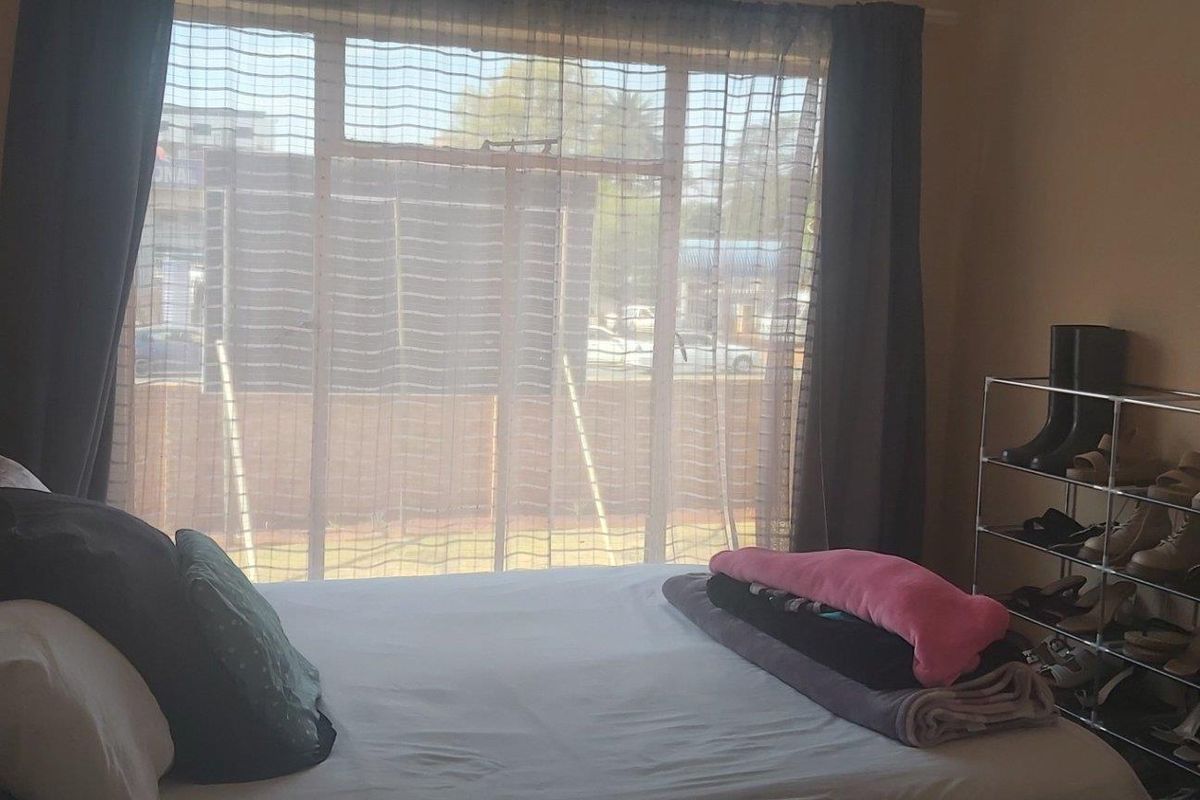 A bedroom featuring a large window with natural light, providing a view of the exterior surroundings.