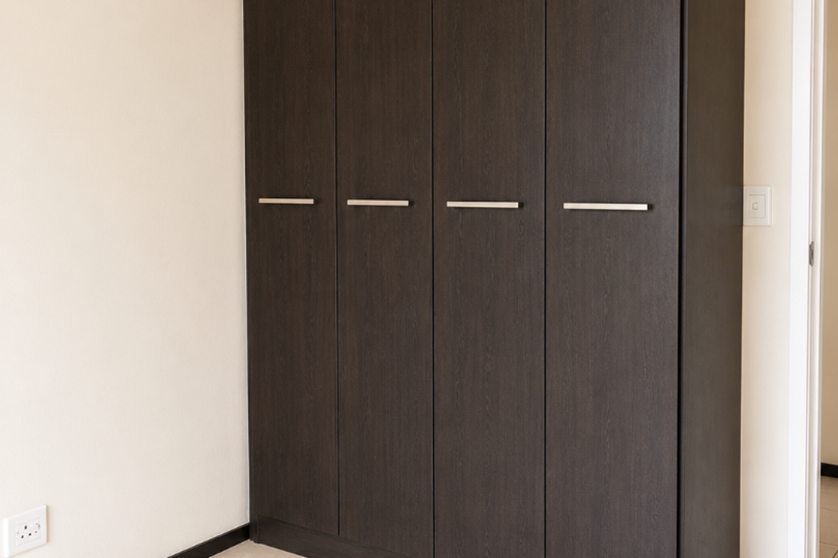 A clean, empty bedroom featuring a modern dark wood built-in wardrobe and neutral tiled flooring.
