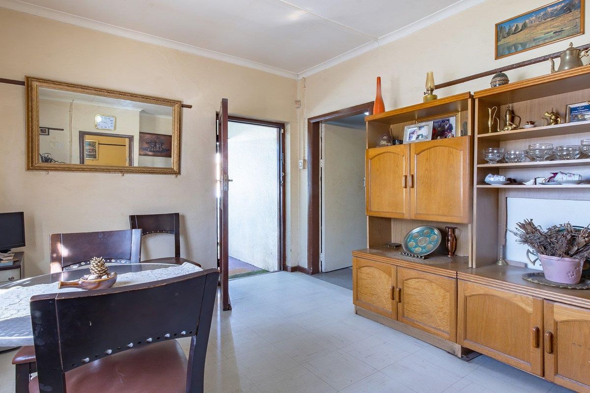 A living area featuring tiled flooring and traditional timber door frames, offering a functional space with potential for modern updates.
