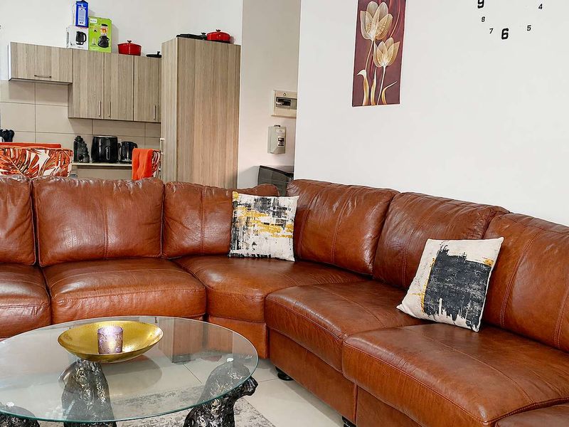 Open plan living area featuring tiled floors and an adjacent kitchen with built-in cabinetry.